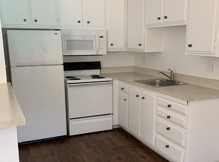 Renovated kitchen with white cabinets and appliances